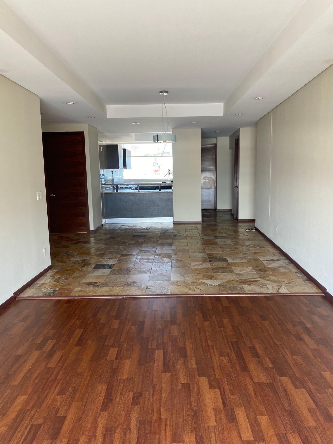 Estancia abierta del departamento con sala, comedor y cocina al fondo